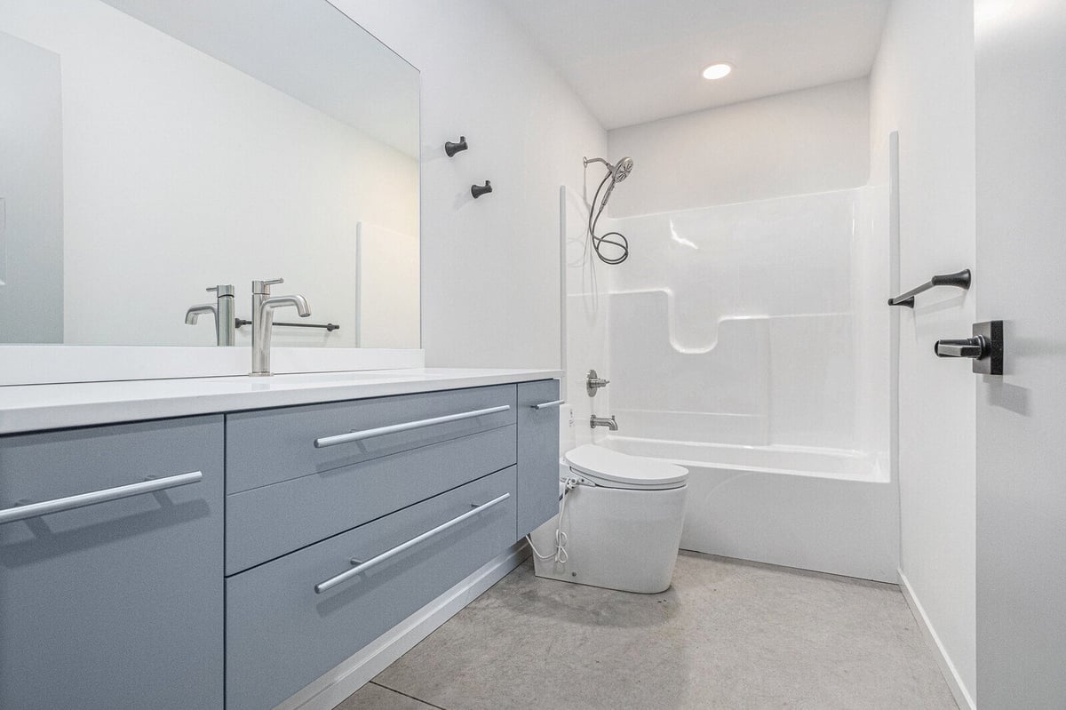 Modern bathroom with a tub and stylish vanity, designed by R Value Homes in West Michigan