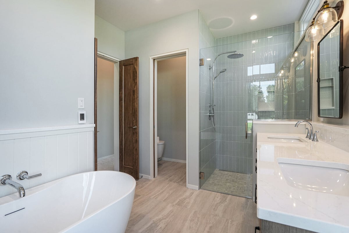 Contemporary bathroom with walk-in shower and sleek freestanding tub, built by R Value Homes in West Michigan