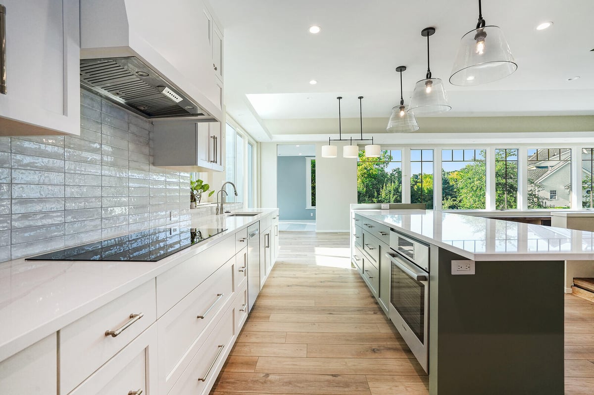 Sleek modern kitchen with white cabinetry and large island, designed by R Value Homes in West Michigan