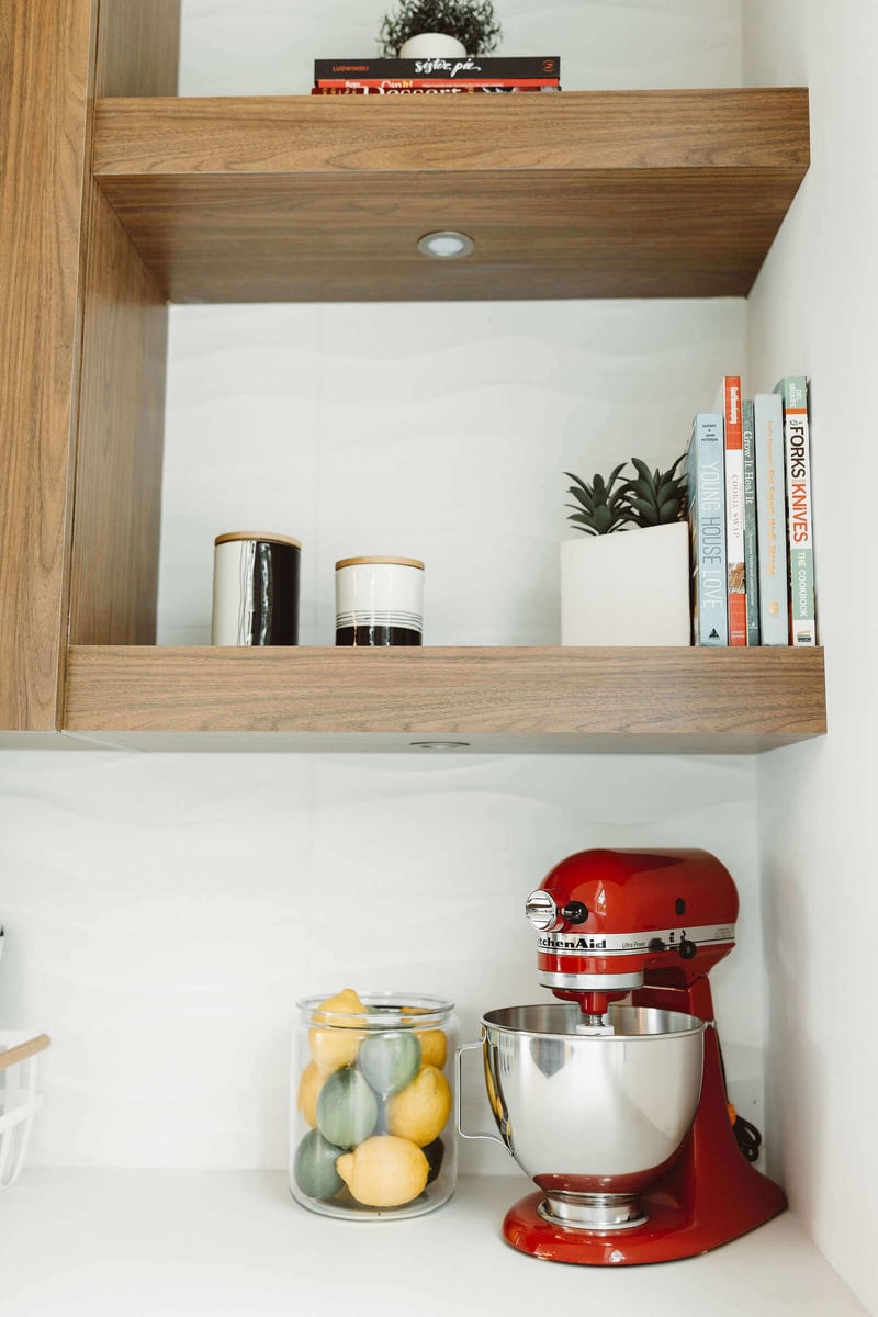 Kitchen with wood shelving and vibrant red mixer in a custom home by R Value Homes, West Michigan