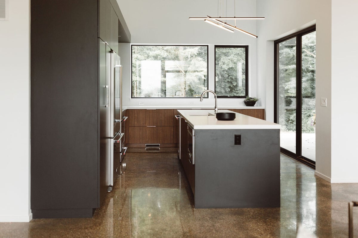 Sleek kitchen island with large windows in a custom home by R Value Homes, West Michigan