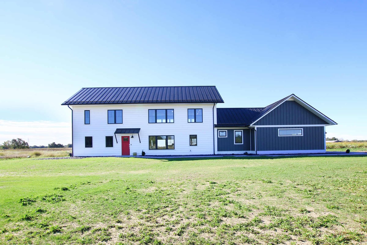 Full exterior view of a custom-built two-story home by R-Value Homes in West Michigan with a modern black roof and white siding