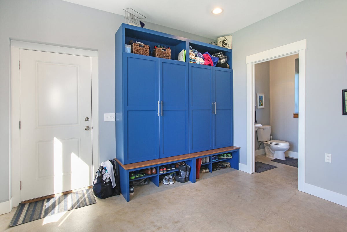 Mudroom in a custom-built West Michigan home by R-Value Homes, featuring vibrant blue cabinets