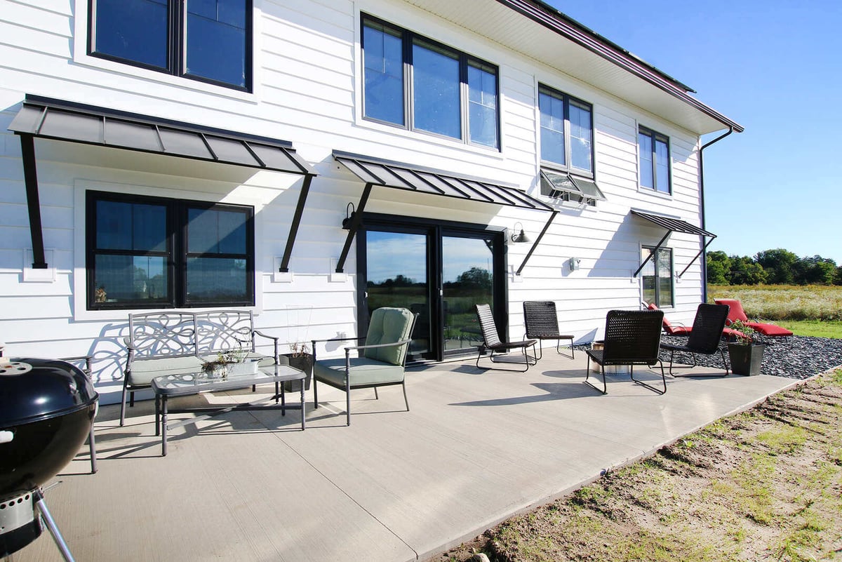 Outdoor patio of a custom home by R-Value Homes in West Michigan, with modern furniture and scenic views