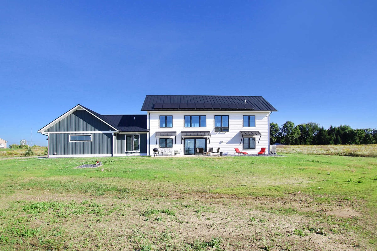 Rear view of a custom-built West Michigan home by R-Value Homes, showcasing a spacious backyard and modern design