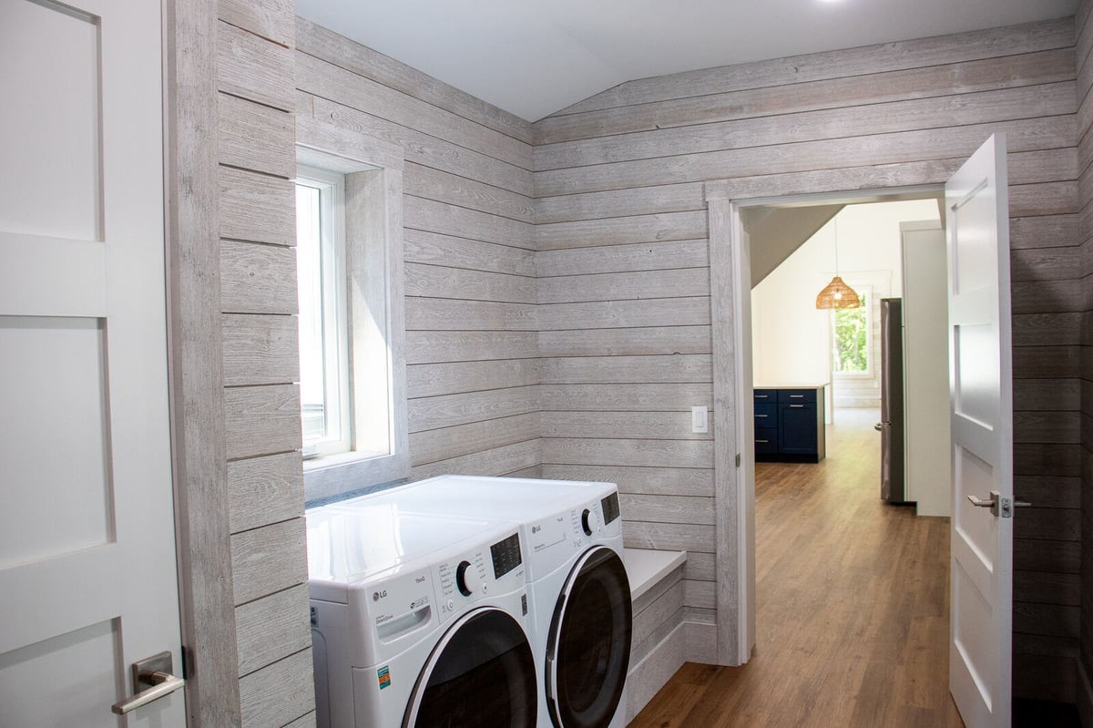 Laundry room in a custom West Michigan home by R-Value Homes, featuring shiplap walls and modern appliances