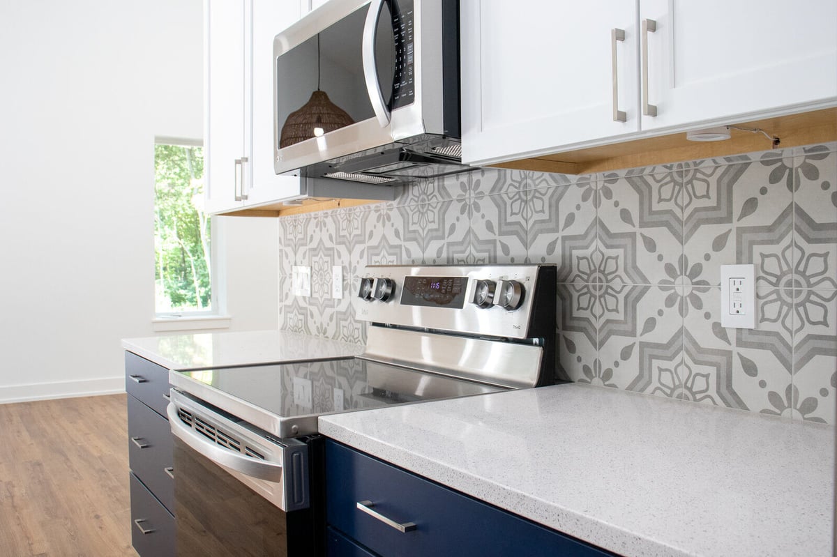 Stainless steel stove with a decorative tile backsplash in a custom West Michigan home by R-Value Homes