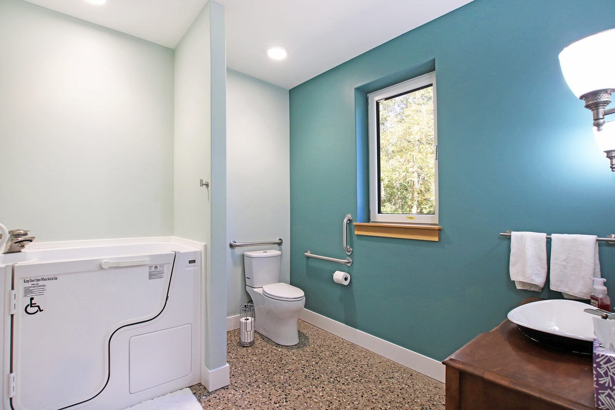 Accessible bathroom in a custom West Michigan home by R Value Homes, featuring a walk-in tub and grab bars