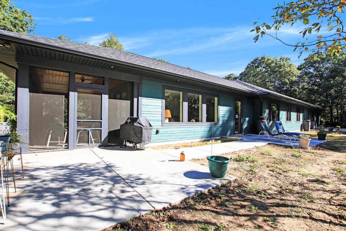 Side view of a custom home in West Michigan by R Value Homes, featuring a screened-in patio and large windows