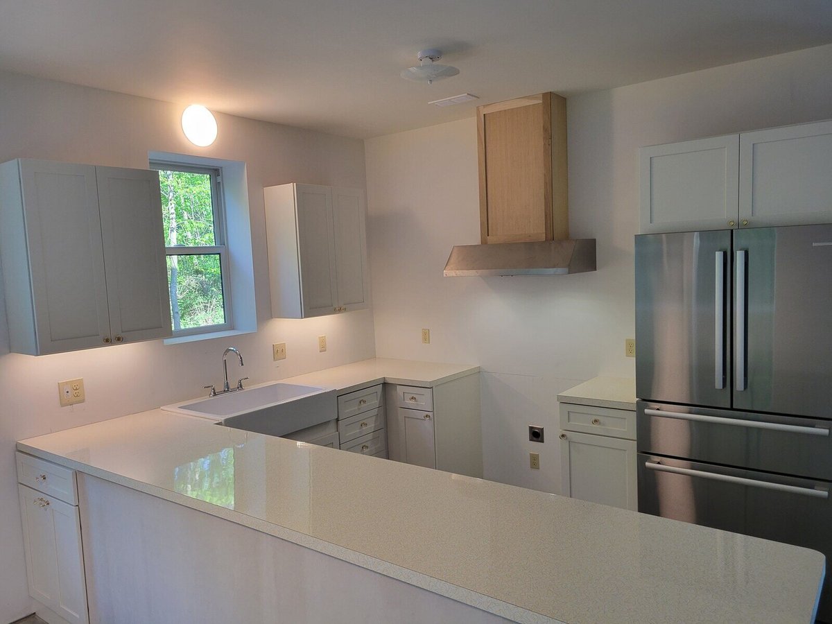 Bright kitchen with white cabinetry and stainless steel appliances in a West Michigan custom home by R Value Homes