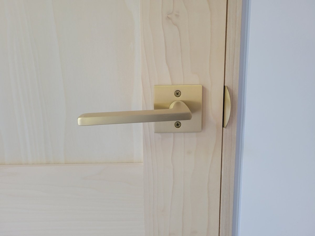 Close-up of a minimalist door handle on a light wood door in a West Michigan custom home by R Value Homes