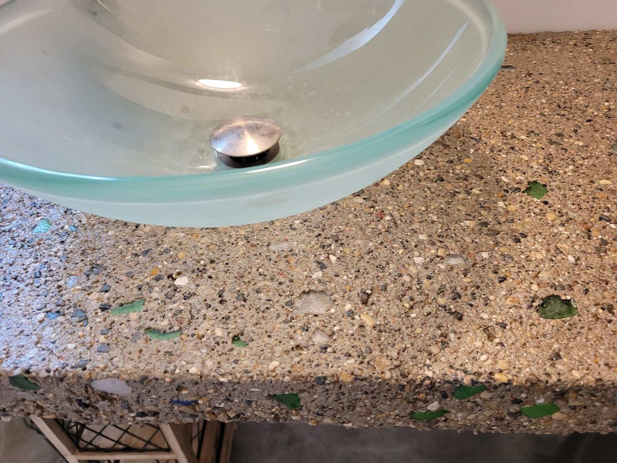 Detailed view of a glass vessel sink on a custom concrete countertop, part of a home by R Value Homes in West Michigan