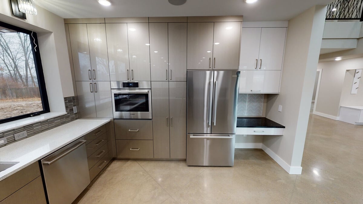 Custom kitchen with white cabinetry and stainless steel appliances, part of a West Michigan home by R Value Homes