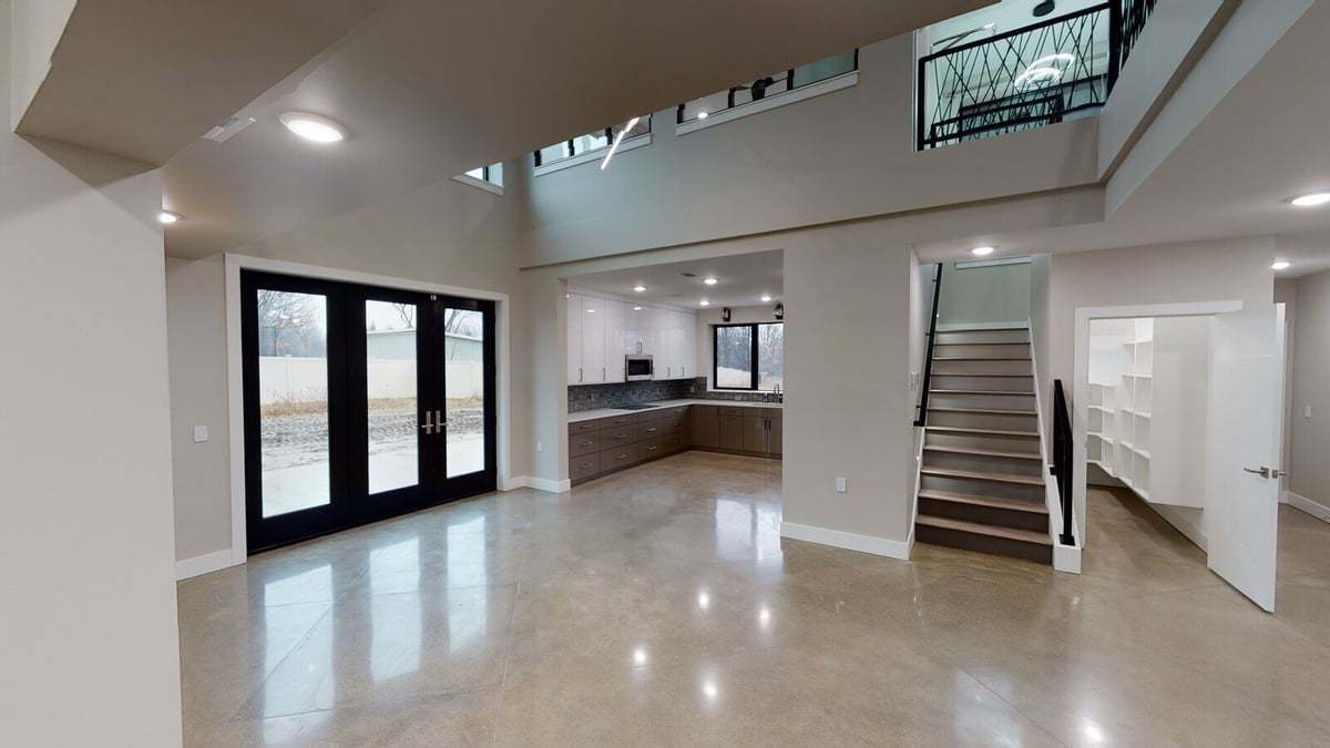 Open-concept living space with high ceilings and a modern kitchen, part of a West Michigan home by R Value Homes