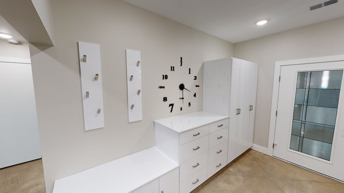 Spacious entryway with minimalist design and a built-in clock, part of a custom West Michigan home by R Value Homes