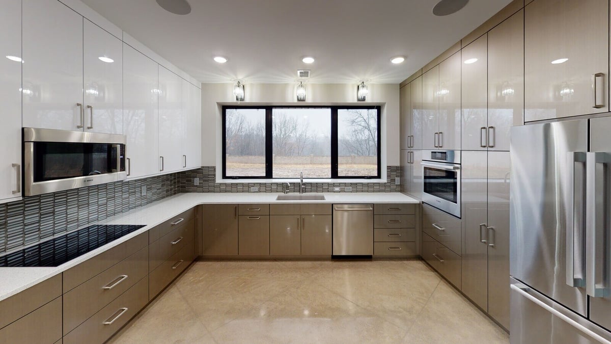 Stylish kitchen with polished concrete floors and natural light, part of a custom home by R Value Homes in West Michigan