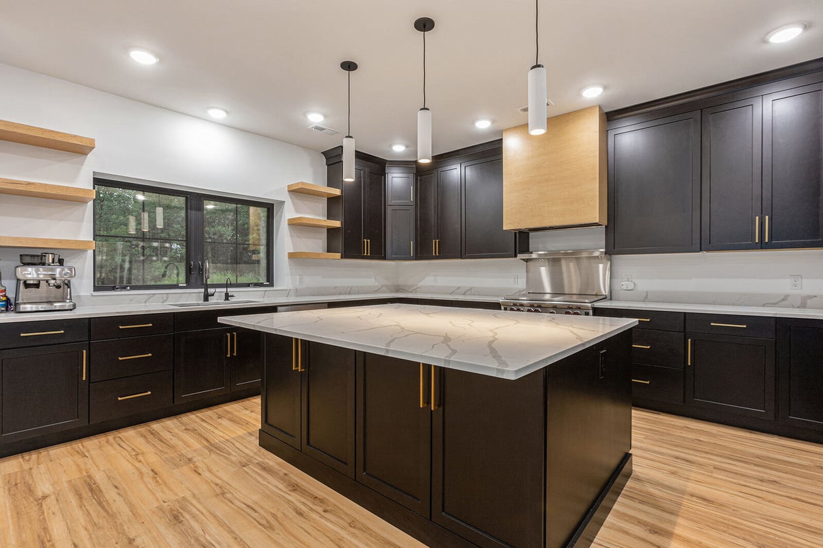 Contemporary kitchen with dark cabinetry and marble countertops by R-Value Homes in West Michigan