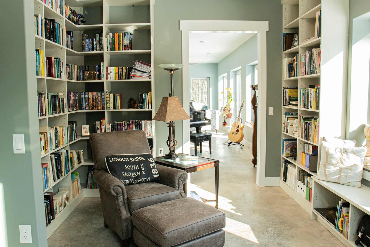 Cozy reading nook with built-in shelves and a recliner chair in a West Michigan custom home by R-Value Homes